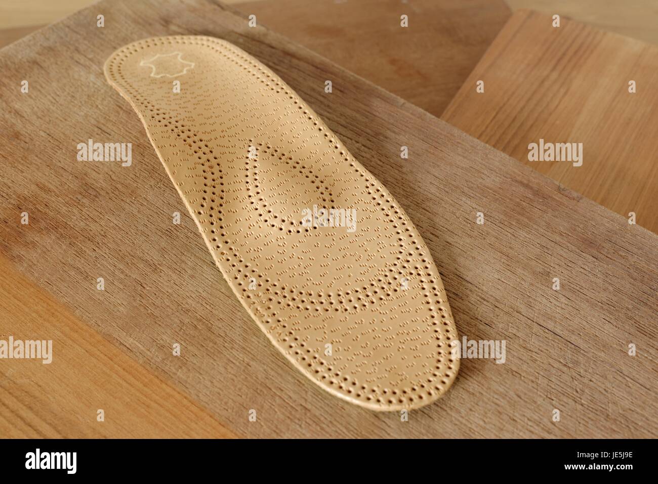 Orthopedic arch support made from leather on a wooden ground Stock Photo
