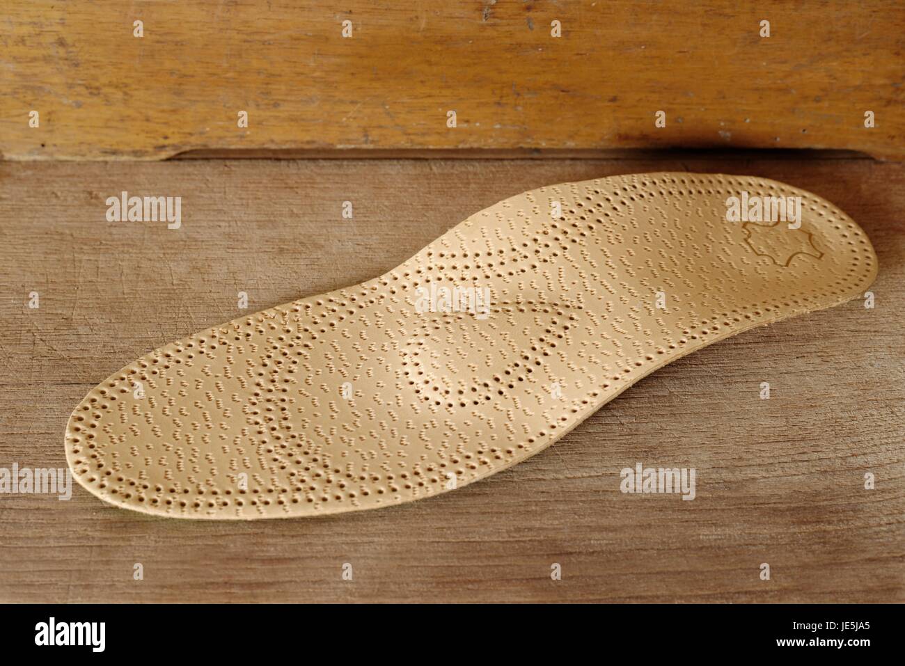 Orthopedic arch support made from leather on a wooden ground Stock Photo
