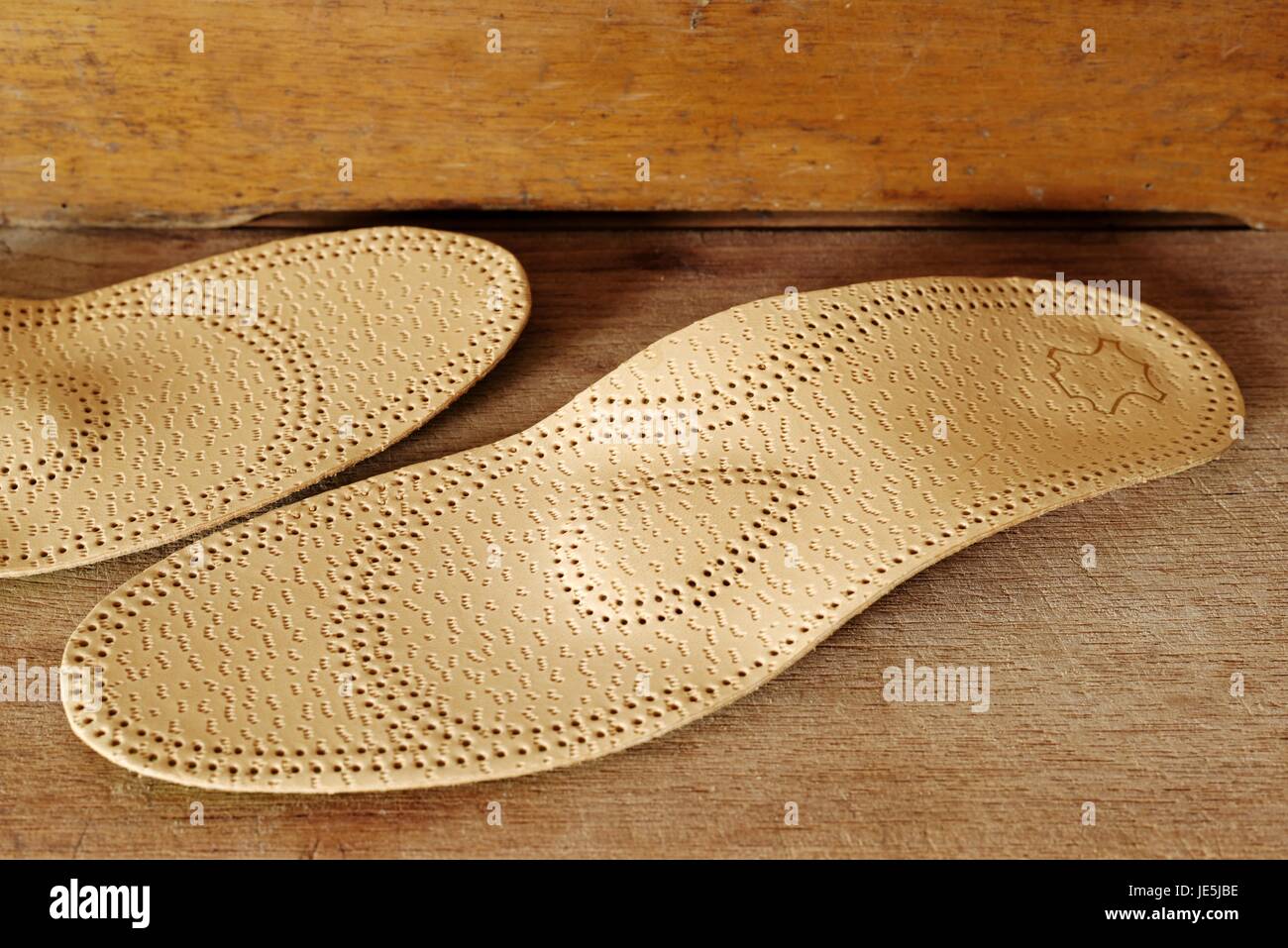 Orthopedic arch support made from leather on a wooden ground Stock Photo