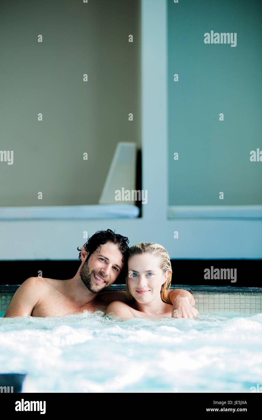 Couple relaxing together in jacuzzi Stock Photo
