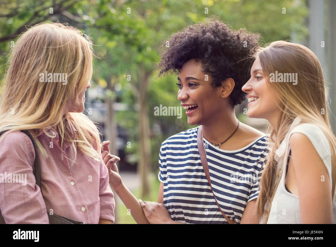 Young women laughing together outdoors Stock Photo - Alamy