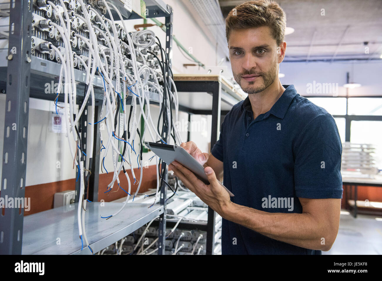 Electrical engineer using digital tablet in factory Stock Photo