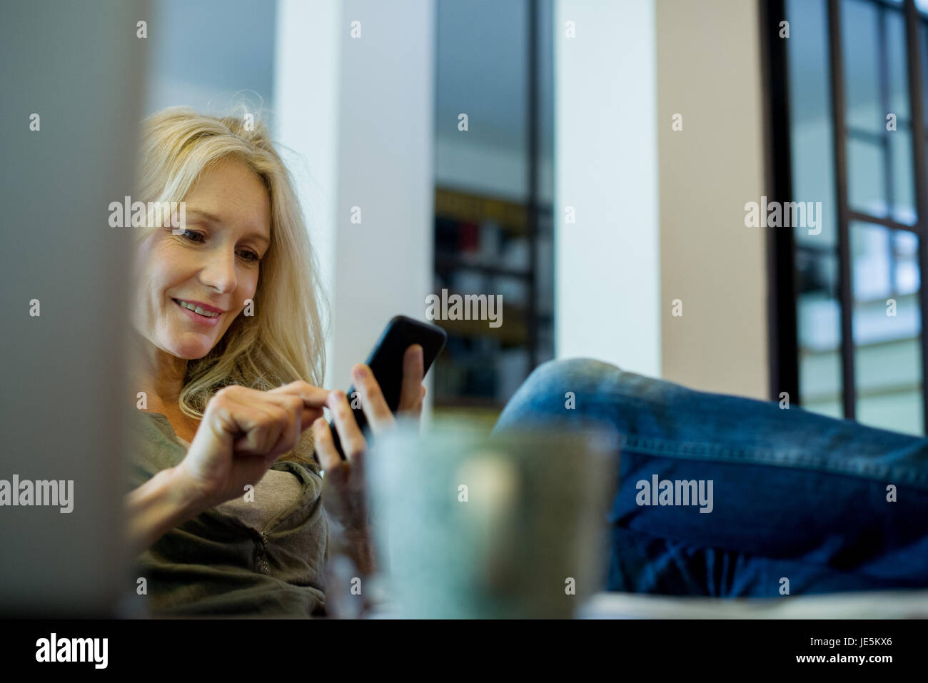 Mature woman relaxing with smartphone Stock Photo