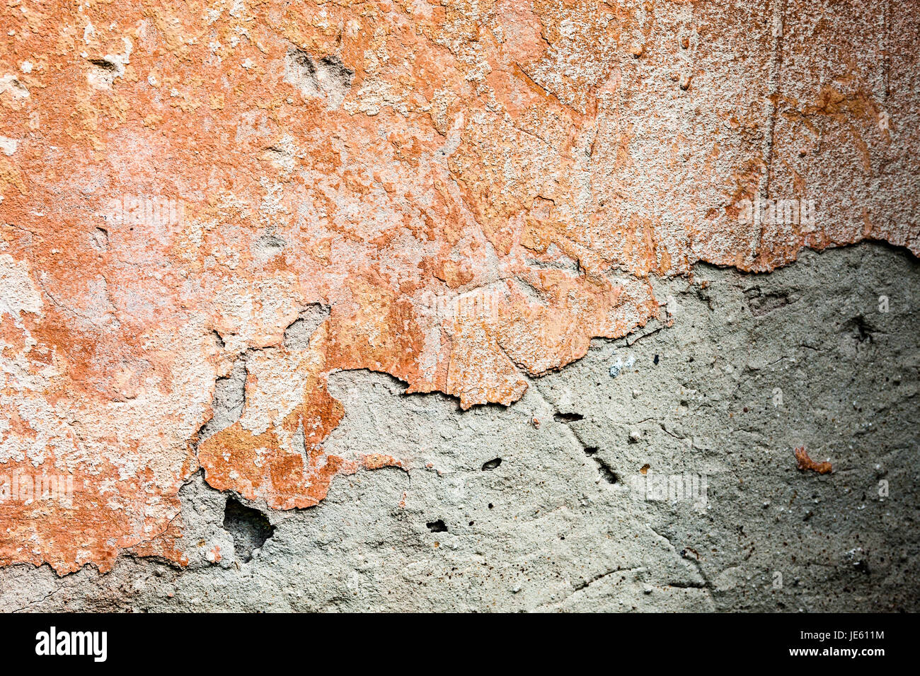 Concrete surface with the remains of orange paint and whitewash and