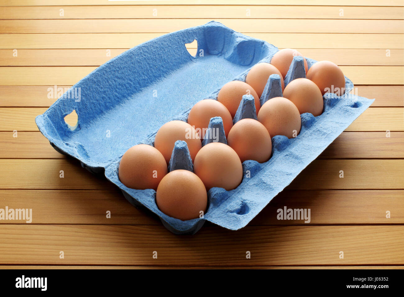 Eggs in Egg Carton on Wooden Background Stock Photo