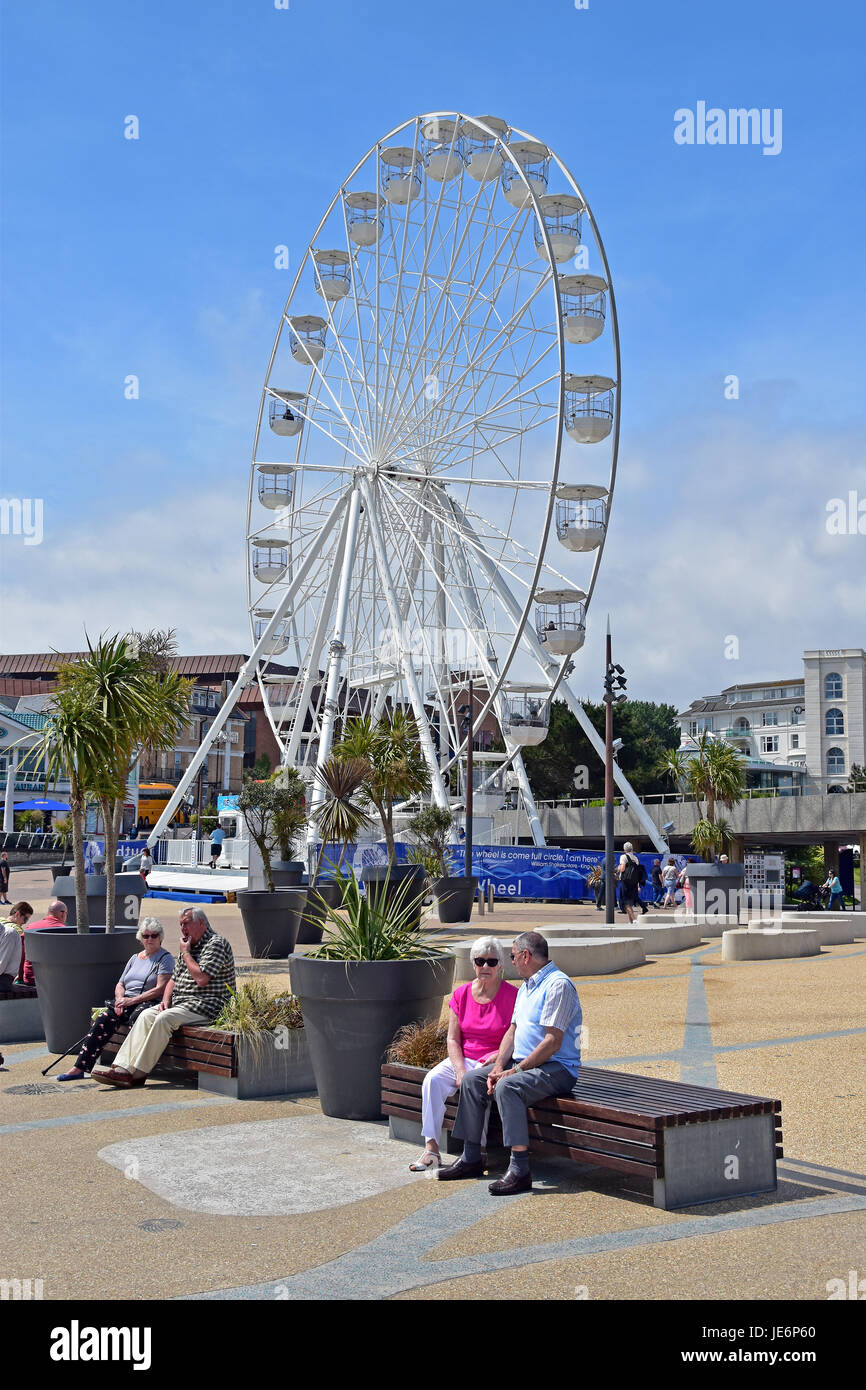 Couples relaxing in front of Bournemouth big wheel located at Pier