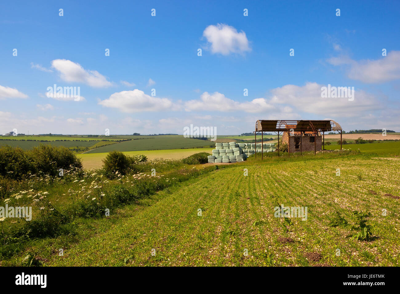 an old farm on a hill with scenic backdrop in the yorkshire wolds under a blue sky in summer Stock Photo