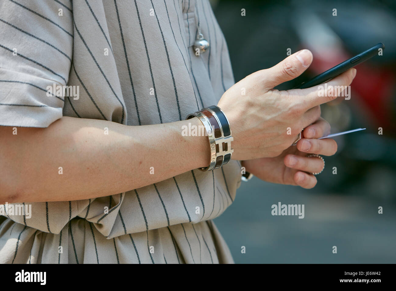 MILAN - JUNE 17: Man with Cartier and Hermes bracelets and smartphone  before Emporio Armani fashion show, Milan Fashion Week street style on June  17 Stock Photo - Alamy