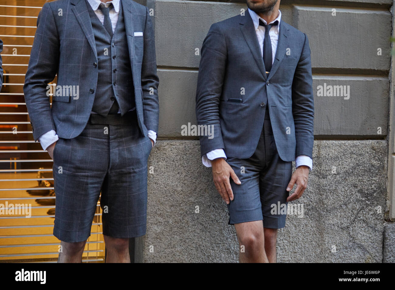 MILAN - JUNE 17: Men with gray suit and short trousers before Versace fashion show, Milan Fashion Week street style on June 17, 2017 in Milan. Stock Photo