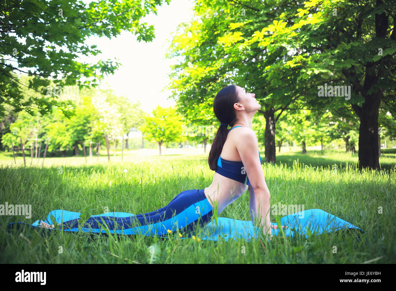 Young girl does stretching outdoors. Workout summer scene. Healthy lifestyle background. Stock Photo