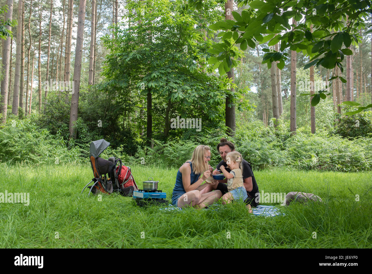 Happy family having dinner in woodland.Camping family concept. Stock Photo