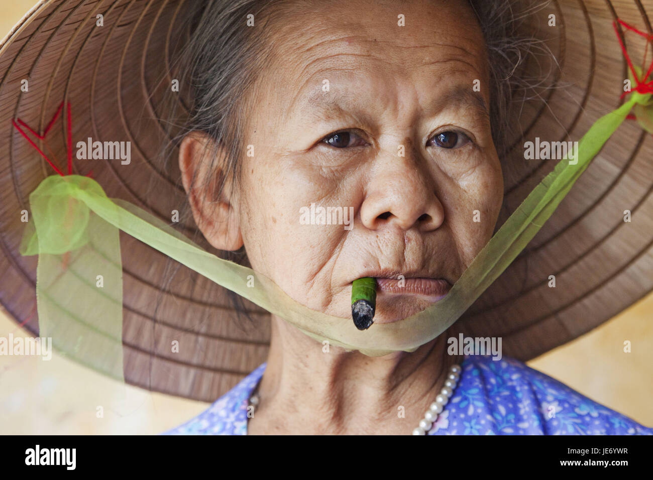 Vietnam, Hoi In, old woman with typical hat smokes cigar, portrait, Stock Photo