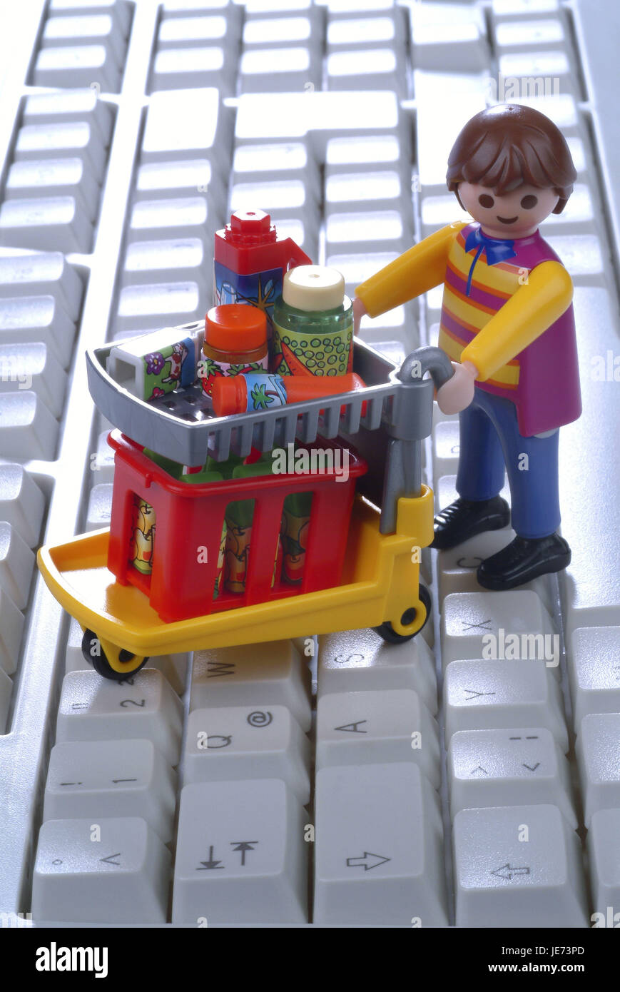 Character by shopping cart on computer keyboard, Stock Photo