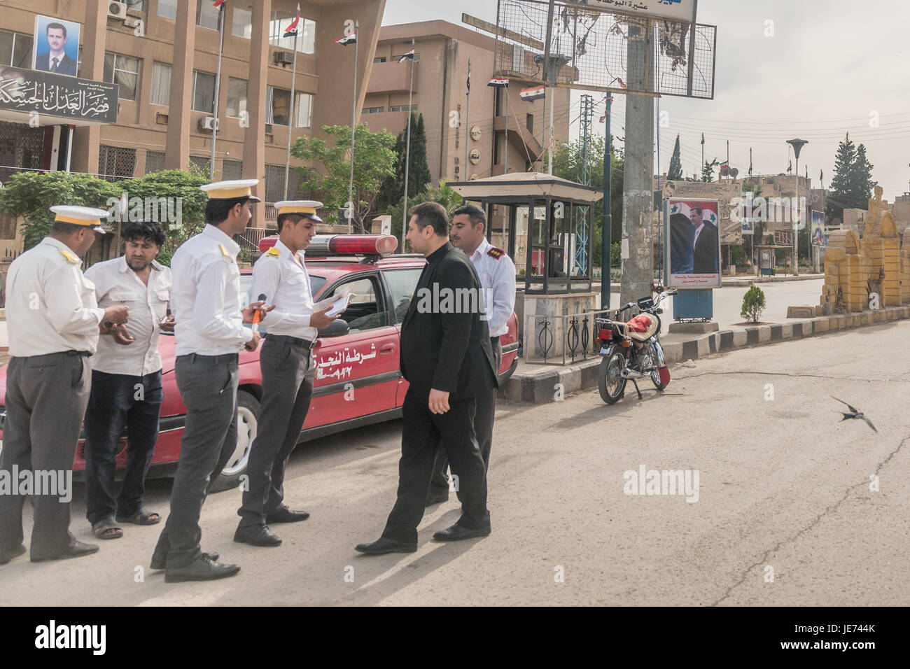 Police checking papers of Asis Firas Farah and posters of Assad on a ...