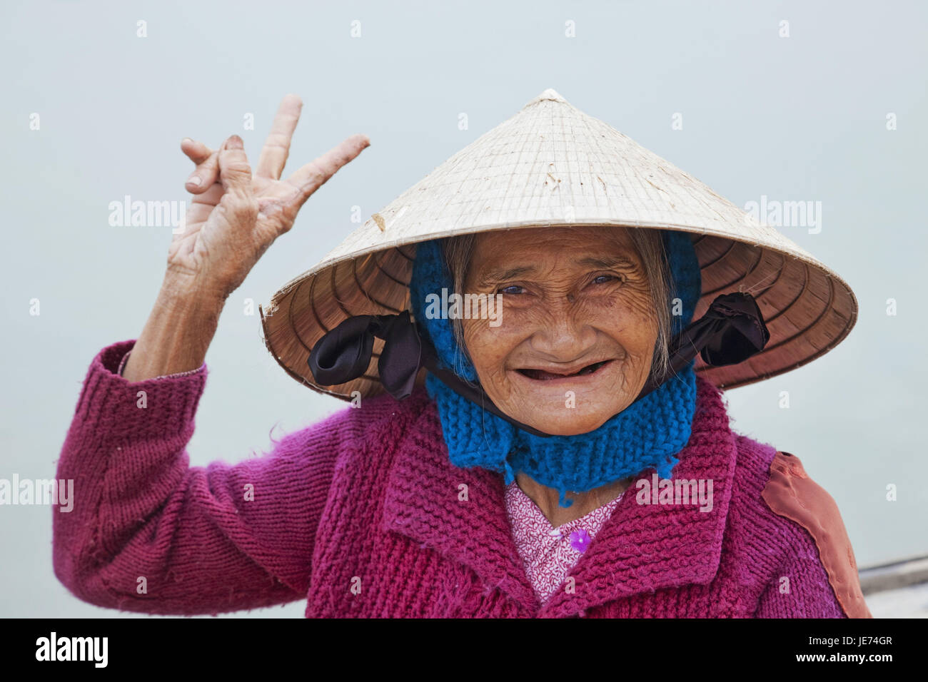 Vietnam, Hoi In, old woman with typical hat, gesture, Victory character, smile, portrait, Stock Photo