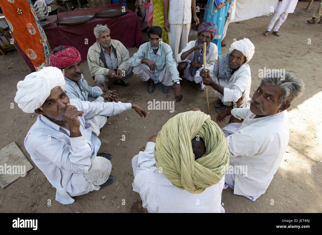 India, Rajasthan, Pushkar, men sit in the circle on the floor, Stock Photo