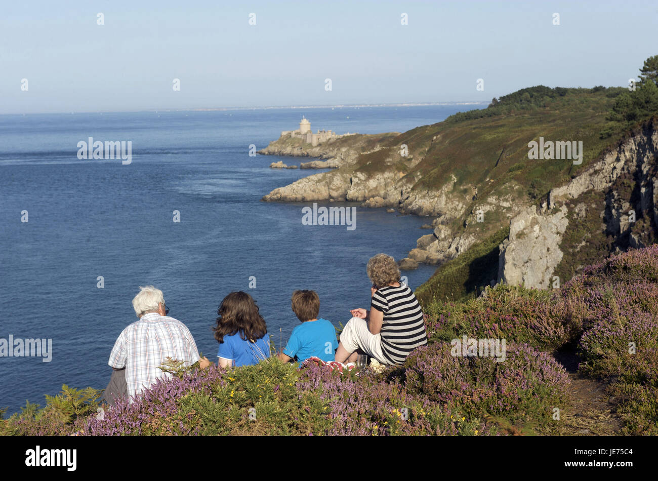 Europe, France, Brittany, Cote D' Emeraude, Cap Frehel, coastal scenery with four people, in the background the castle fort la bar, Stock Photo