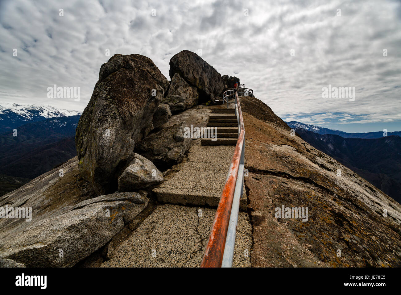 Steep Moro rock staircase rises into a cloudy sky high above the surrounding valley of Sequoia National Park Stock Photo