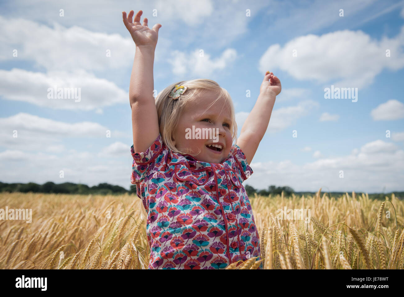 happy little girl with arms raised Stock Photo - Alamy