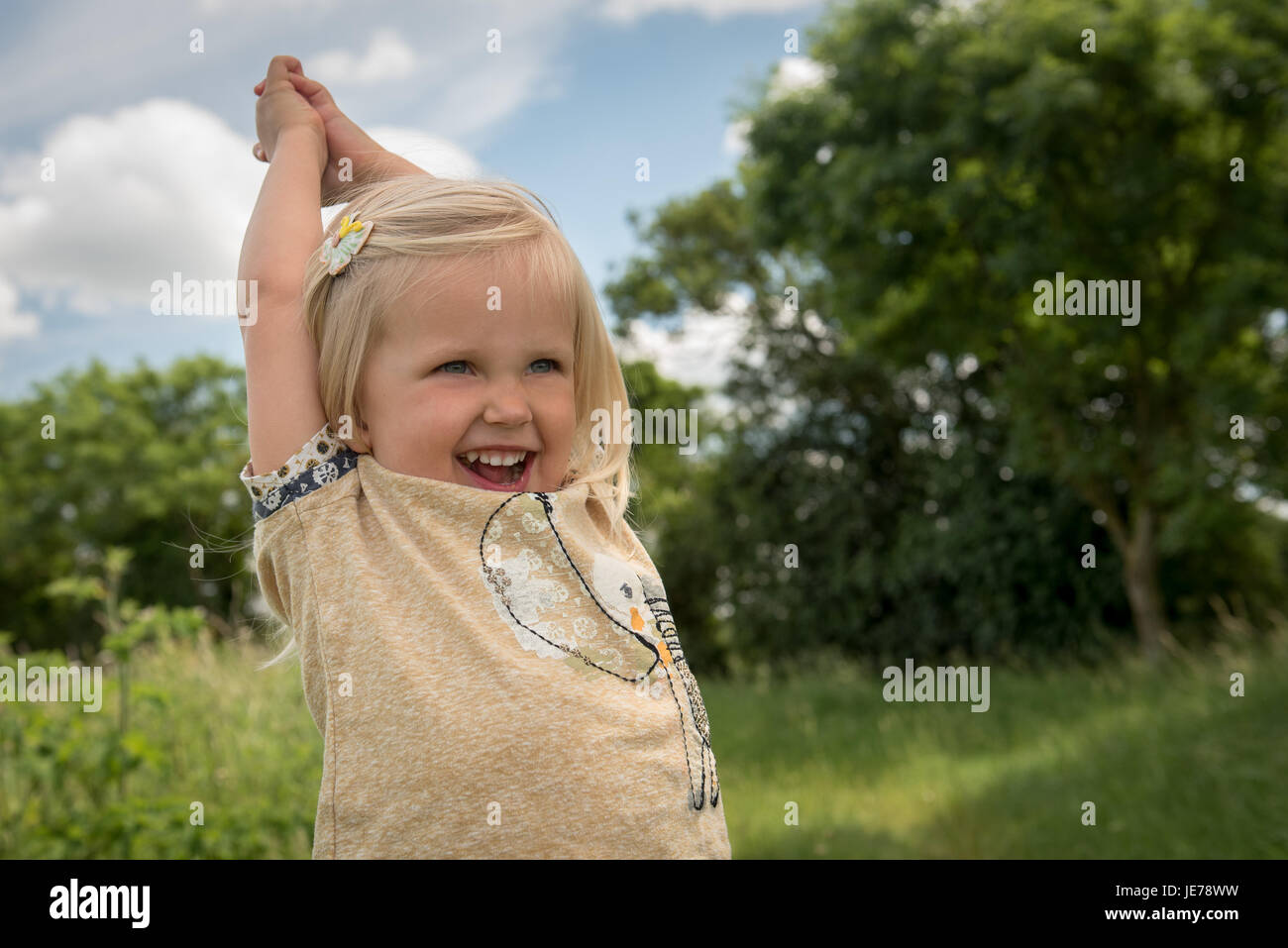 happy little girl with arms raised Stock Photo - Alamy