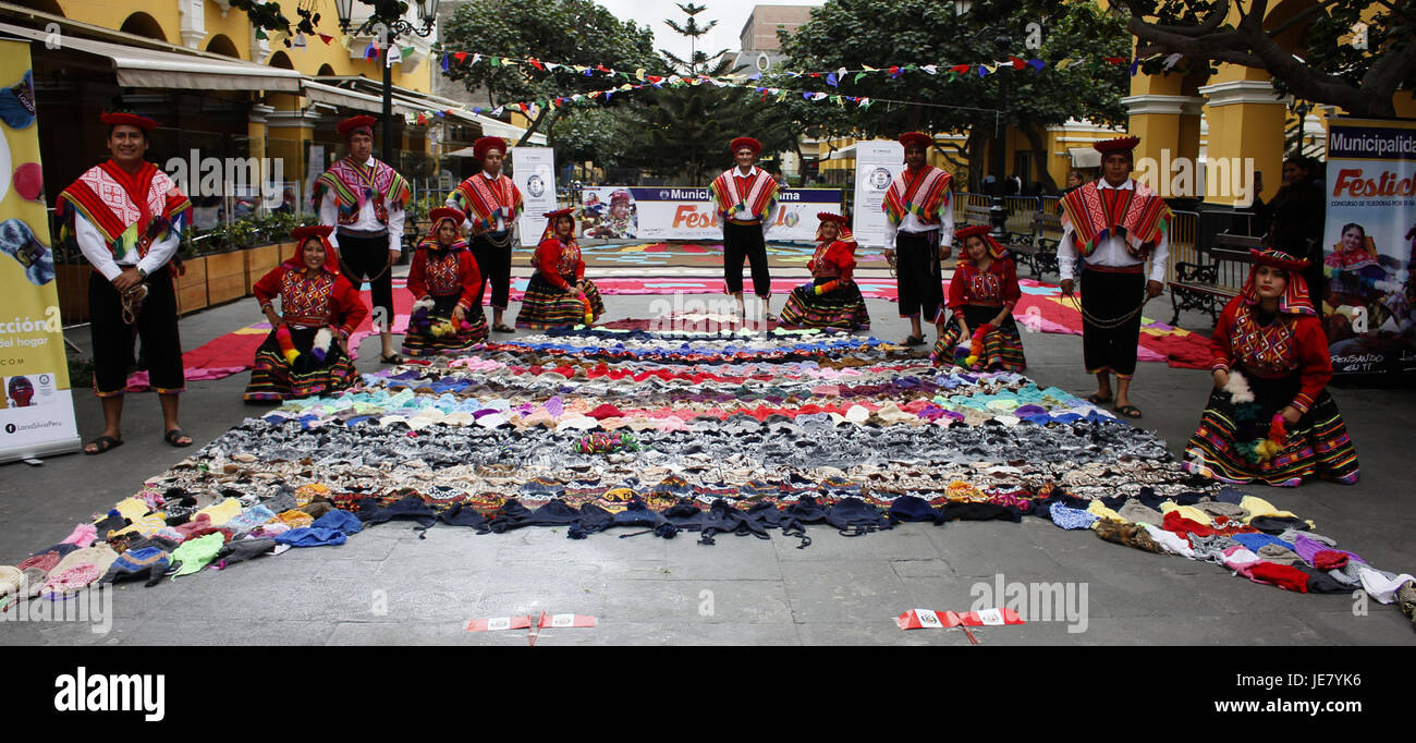 Lima, Peru. 22nd June, 2017. People pose in front of a giant 'chullo', a hand-woven traditional Peruvian cap, as part of the activity 'a coat for a smile' in Lima, Peru, on June 22, 2017. According to local press, Lima presented a giant chullo formed by small chullos that will be donated to people affected by the cold weather in 'Ticlio Chico'. Credit: Luis Camacho/Xinhua/Alamy Live News Stock Photo