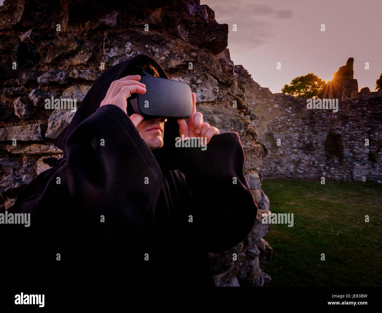 Picture taken 19/06/17 Embargoed until 00.01 23/06/17: St Augustine’s Abbey – part of Canterbury’s World Heritage site - has been ‘rebuilt’ in virtual reality as part of a collaboration between English Heritage and the University of Kent. From 24th June, visitors will be able to sit in a new pod in the visitor centre and experience a virtual tour through the ornate and brightly decorated buildings as they would likely have been in the early 16th century, just before their destruction by Henry VIII.  This will be the first time VR has been used at an English Heritage site. An actor with headset Stock Photo