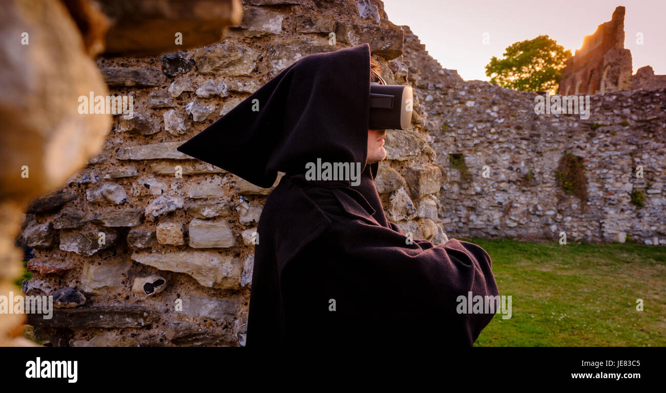 Picture taken 19/06/17 Embargoed until 00.01 23/06/17: St Augustine’s Abbey – part of Canterbury’s World Heritage site - has been ‘rebuilt’ in virtual reality as part of a collaboration between English Heritage and the University of Kent. From 24th June, visitors will be able to sit in a new pod in the visitor centre and experience a virtual tour through the ornate and brightly decorated buildings as they would likely have been in the early 16th century, just before their destruction by Henry VIII.  This will be the first time VR has been used at an English Heritage site. An actor with headset Stock Photo
