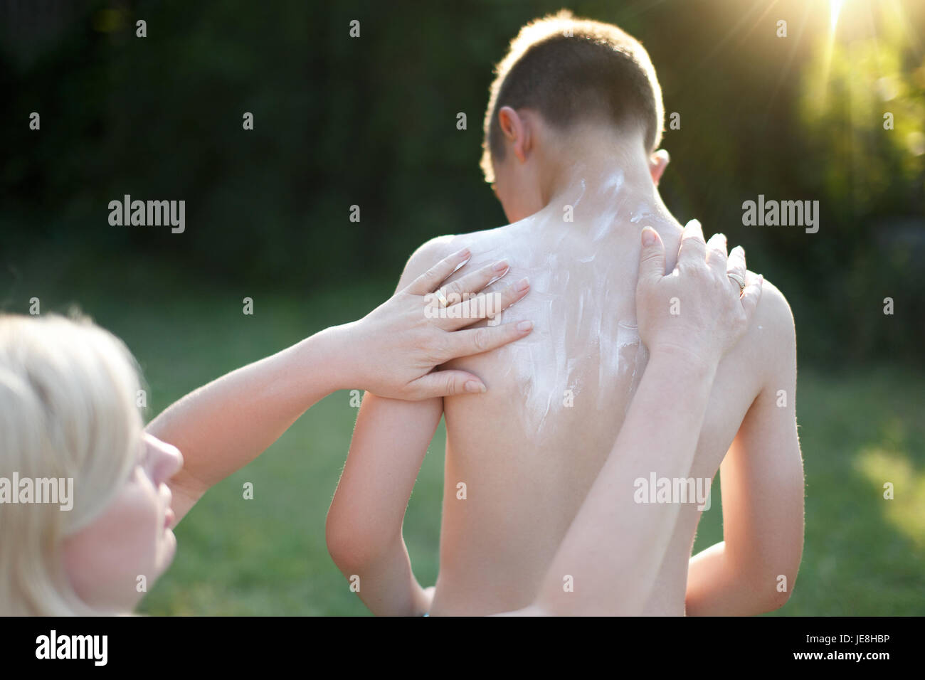 Mother applying sunscreen creme for little son Stock Photo