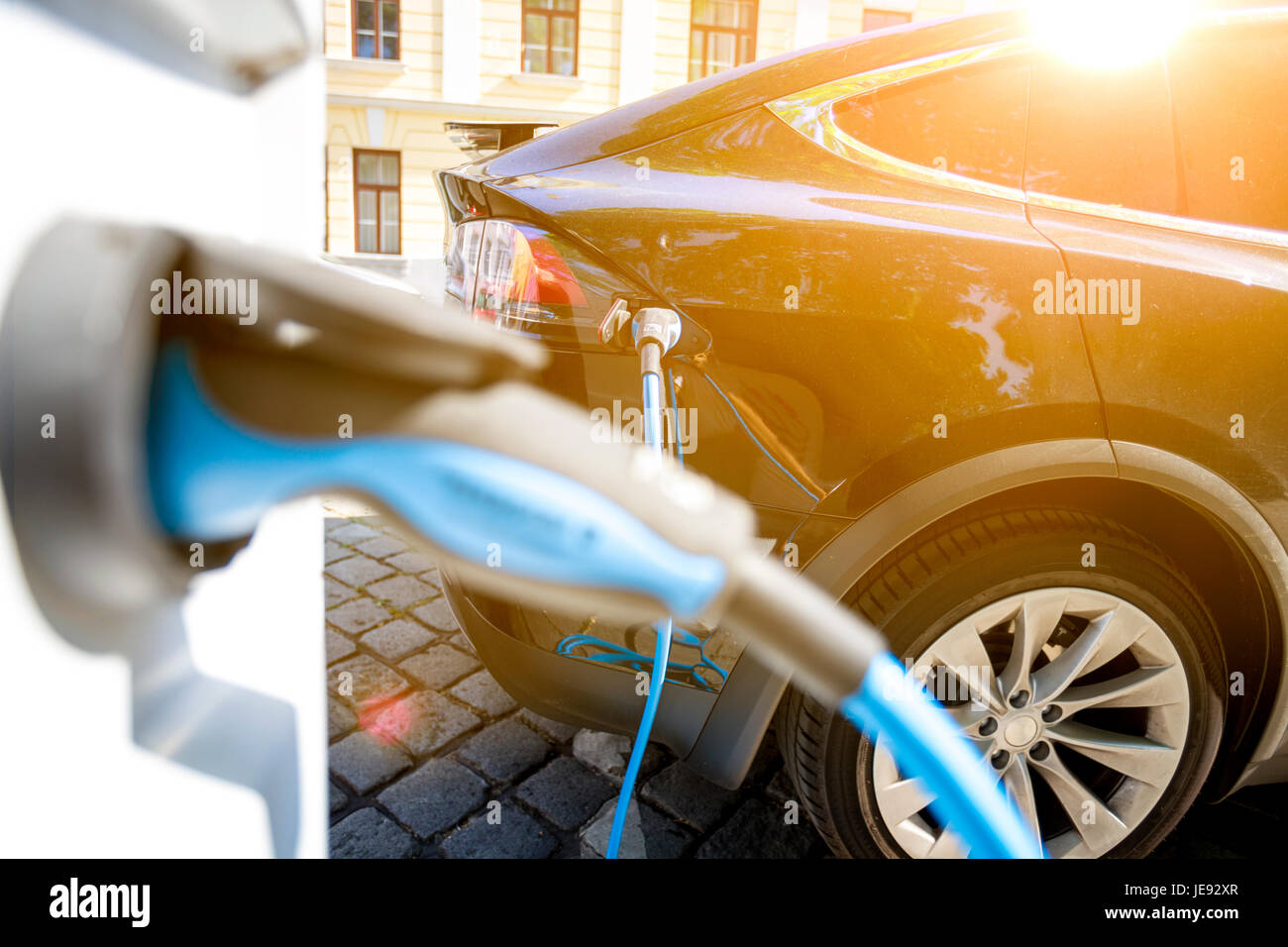 Close up of the power supply plugged into an electric car being charged Stock Photo