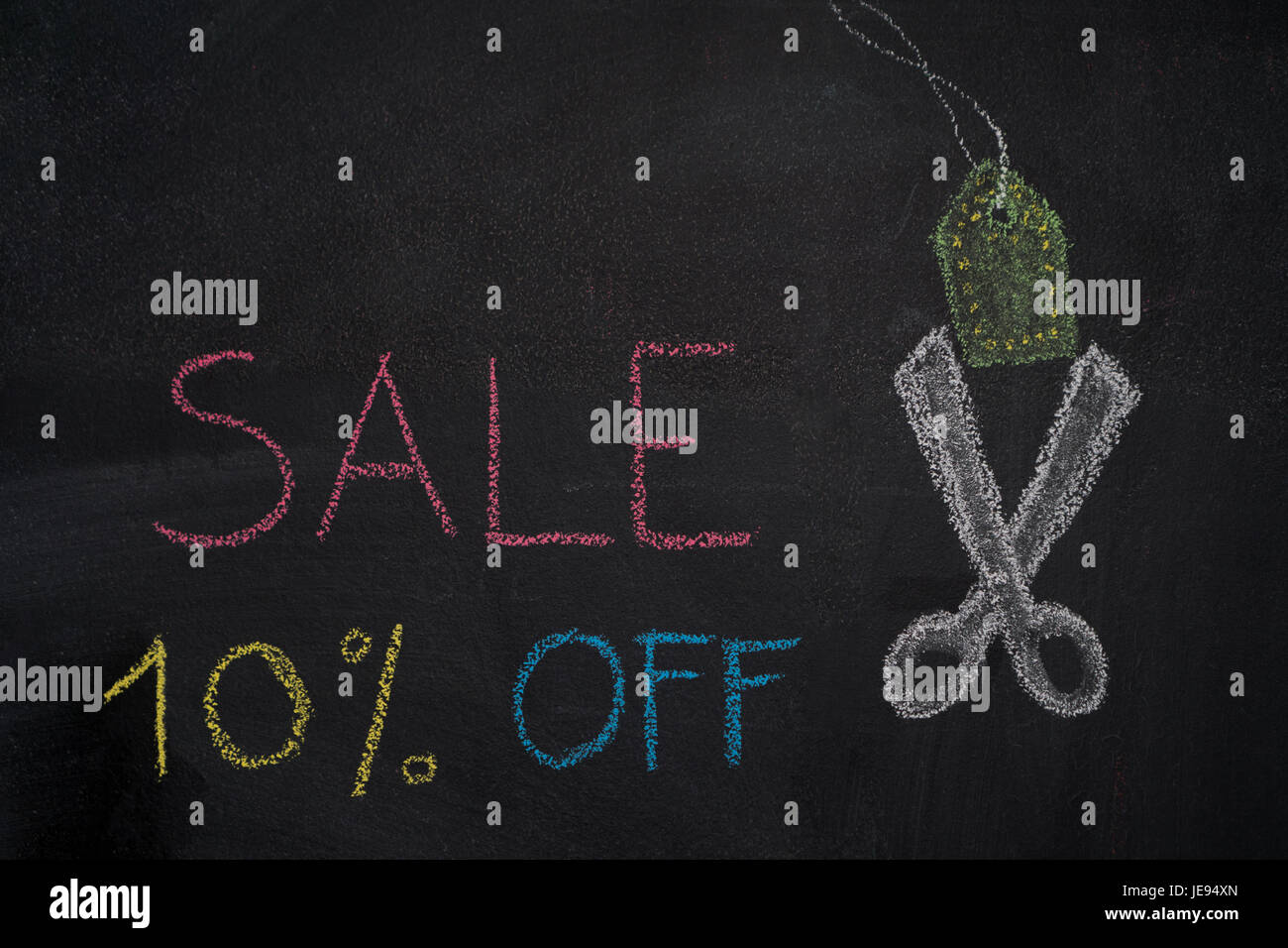 Sale 10% off. Sale and discount price sign with scissors cutting price tag drawn with chalk on blackboard Stock Photo