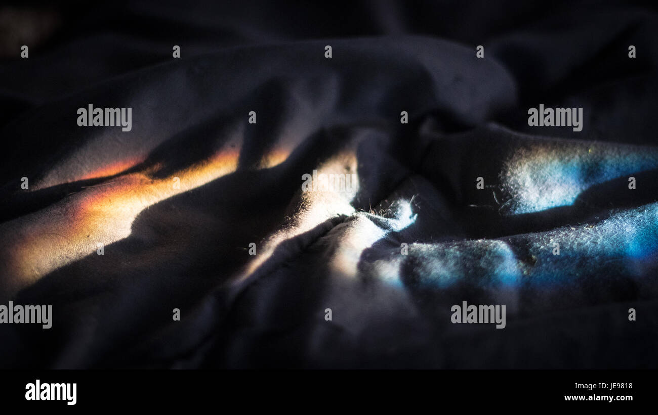 Refracted sunlight ripples across folds in a blanket Stock Photo Alamy