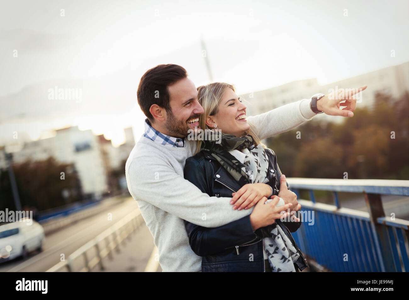Happy young couple hugging and kissing on bridge Stock Photo - Alamy