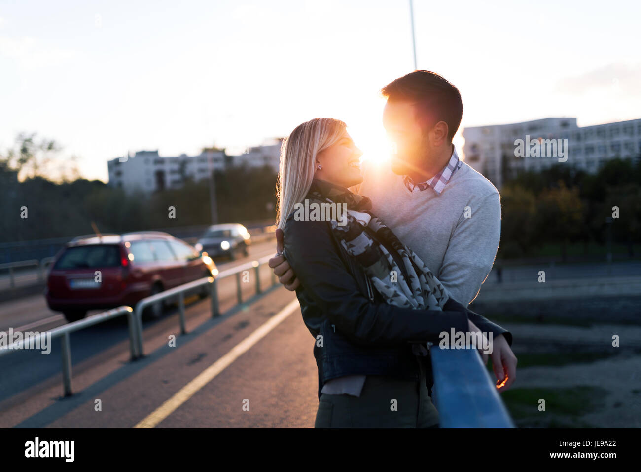 Happy young couple hugging and kissing on bridge Stock Photo - Alamy