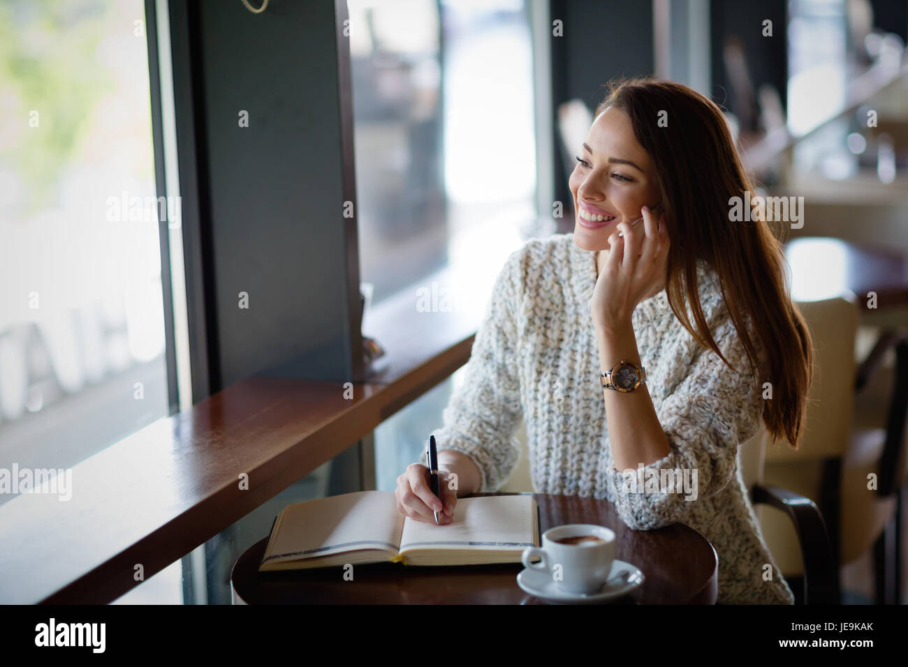 Beautiful woman drinking coffee in restaurant alone Stock Photo