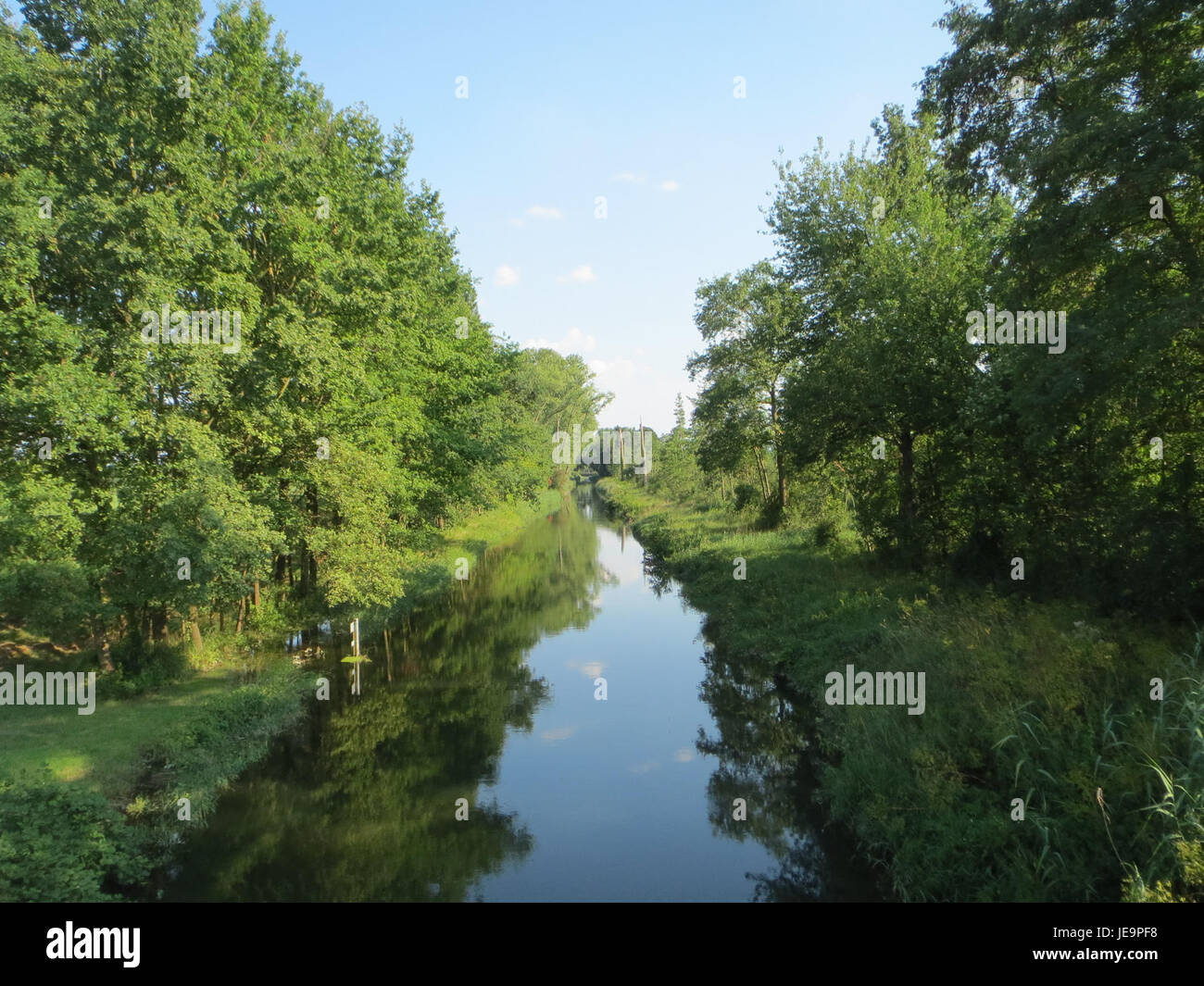 The Rheinniederungskanal is a man-made canal in Germany, built to regulate the flow of the Rhine River and prevent flooding. It is a key part of the region's flood control system, improving water management for surrounding agricultural lands and urban areas. The canal also supports local ecosystems and provides a navigation route for boats and ships. Stock Photo