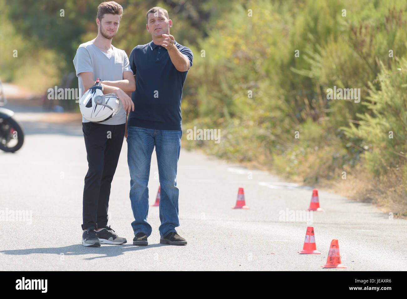 driving instructor explains man the exercise in motordrome Stock Photo
