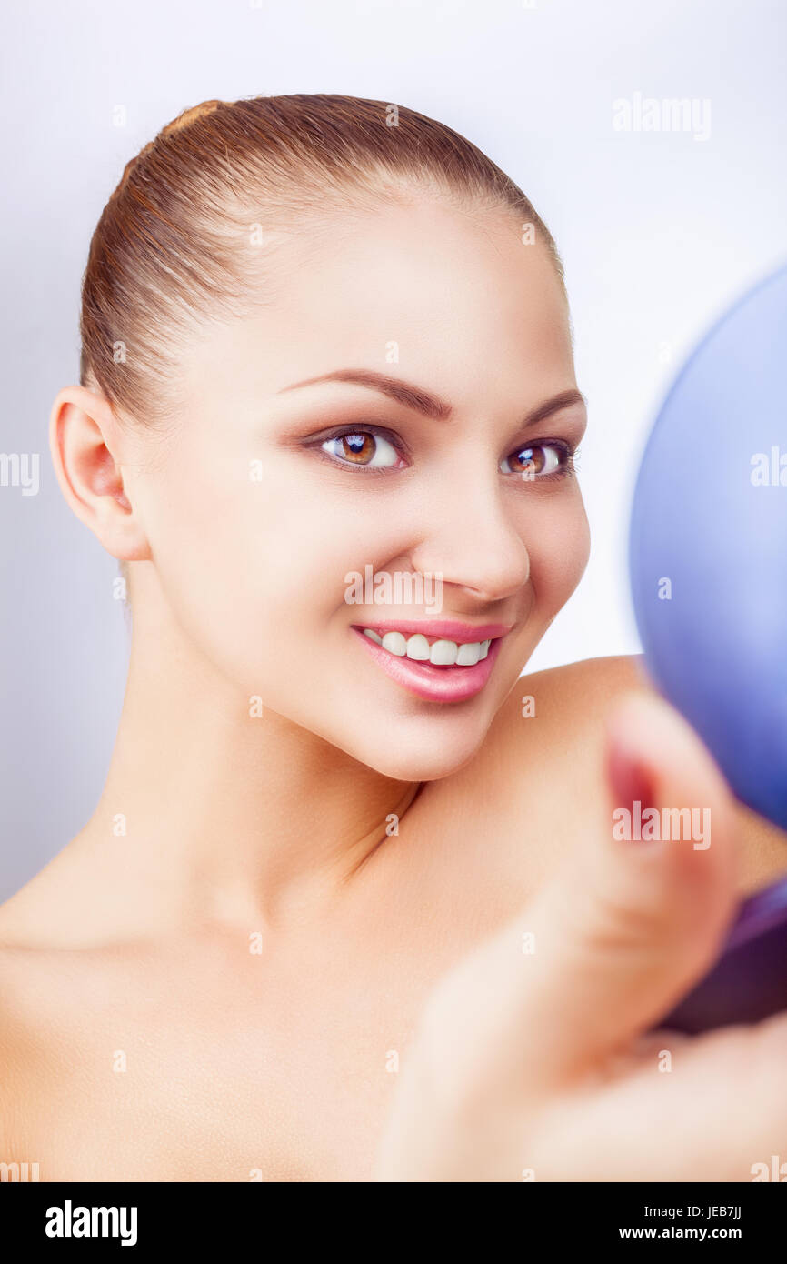 Beautiful young woman looking in the mirror on white background Stock ...
