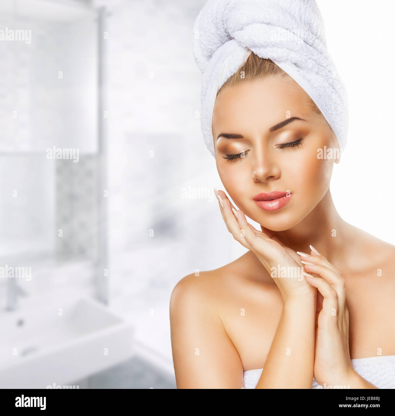 Beautiful young woman's face with a towel on her head in bathroom Stock Photo Alamy