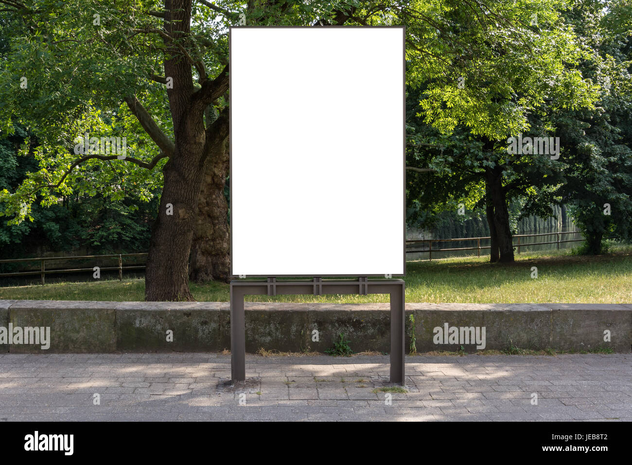 A blank ad space sign isolated in front of a park Stock Photo - Alamy