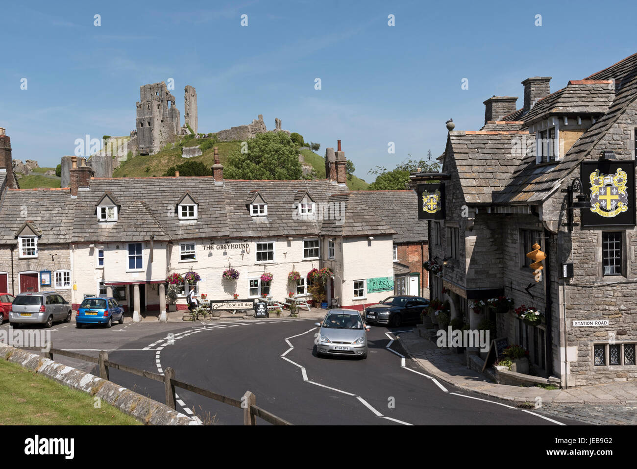 The Greyhound pub in Corfe Castle Dorset England UK overlooked by the castle ruins. Stock Photo