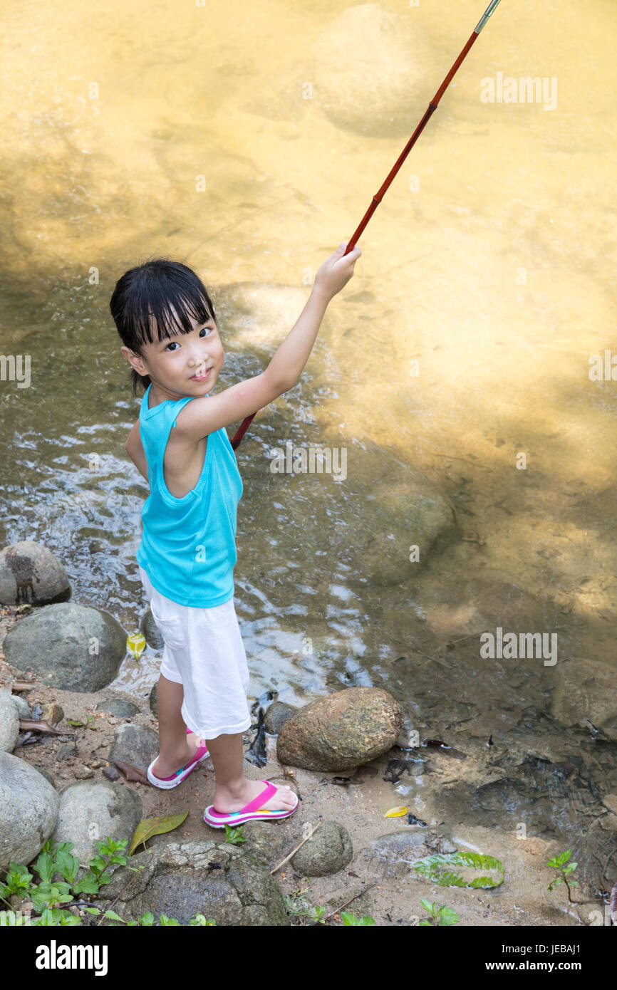 Happy Asian Chinese little girl angling with fishing rod at the river shore  Stock Photo - Alamy