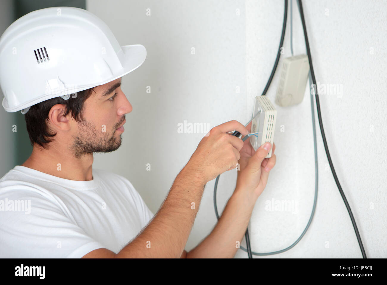 electrician man worker installing a thermostat Stock Photo Alamy