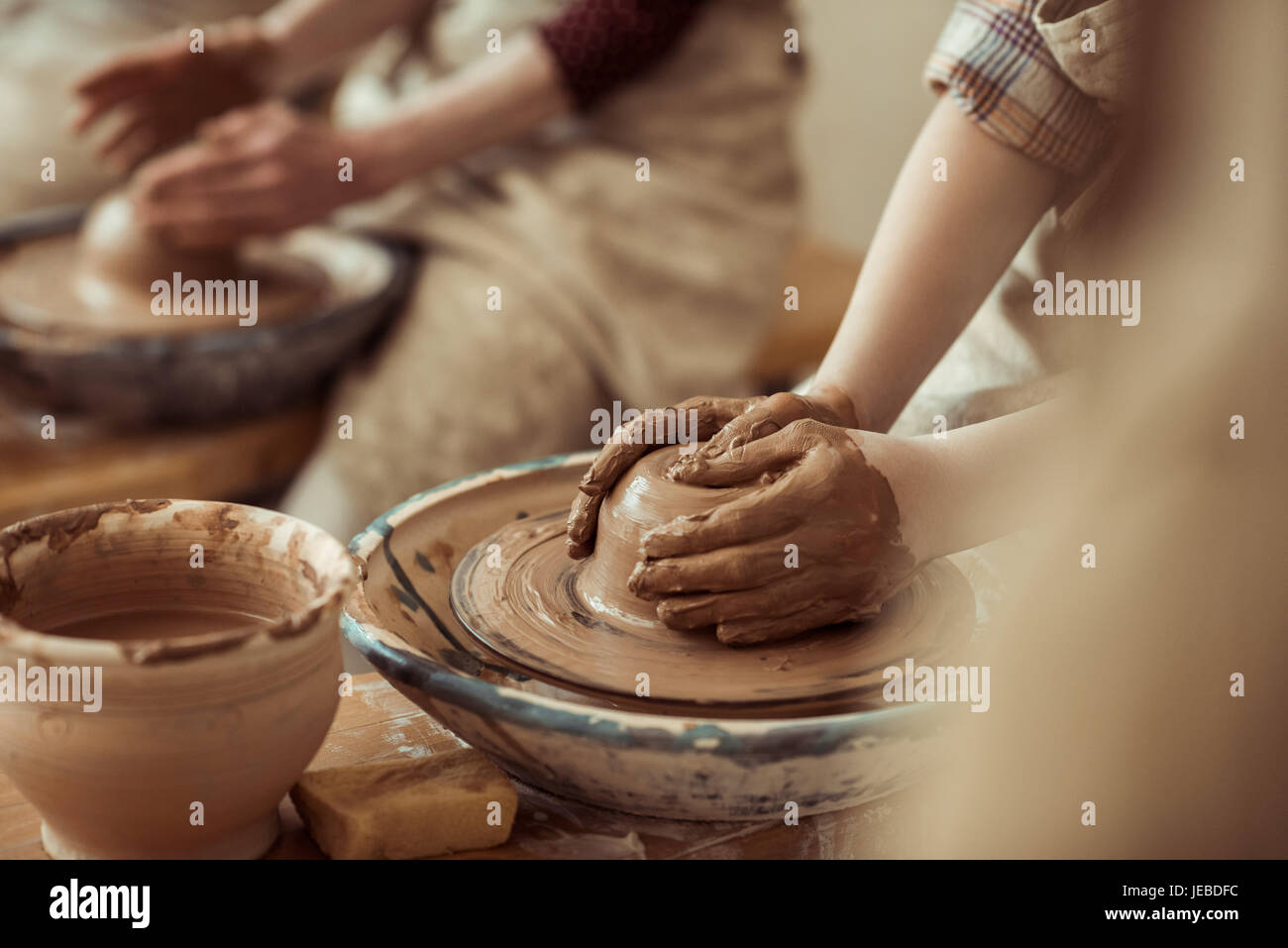 Close up of child hands working on pottery wheel at workshop Stock Photo