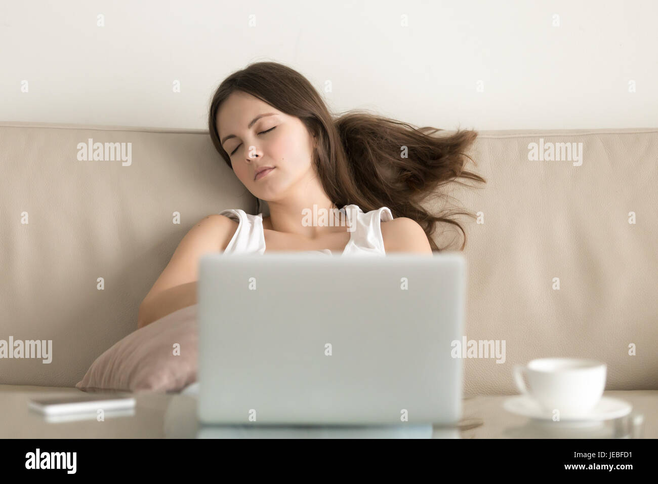 Woman falling asleep on sofa in front of laptop Stock Photo Alamy