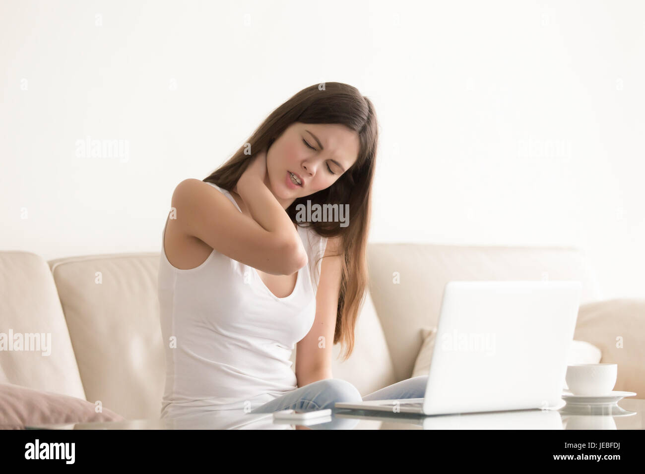 Young woman suffering from pain in tense neck Stock Photo