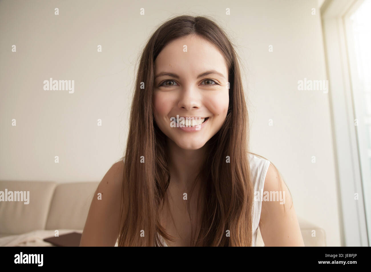 Emotive headshot portrait of smiling young woman Stock Photo