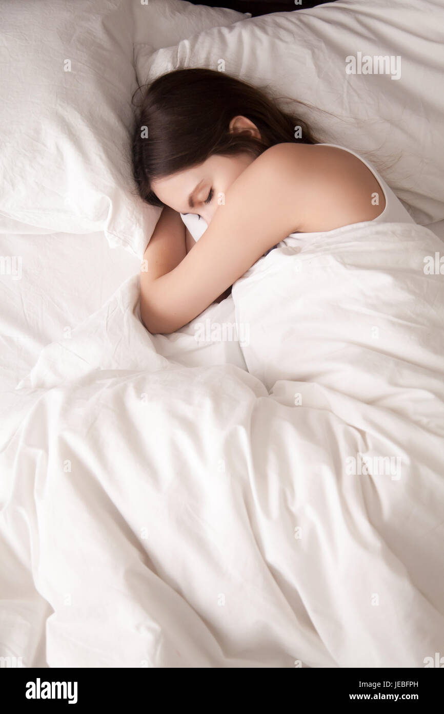 Female student lying in bed until late morning Stock Photo