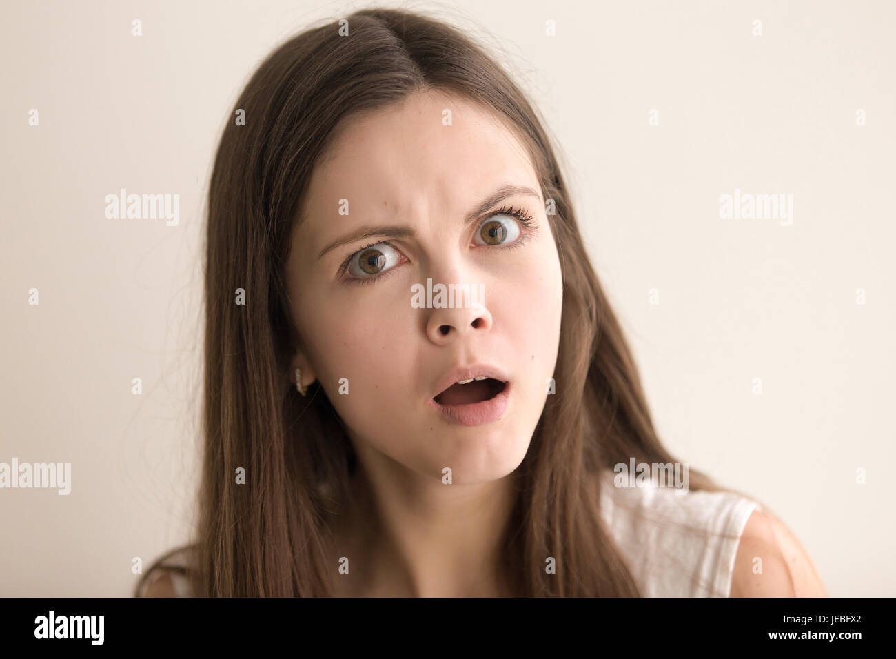 Emotive headshot portrait of shocked young woman Stock Photo
