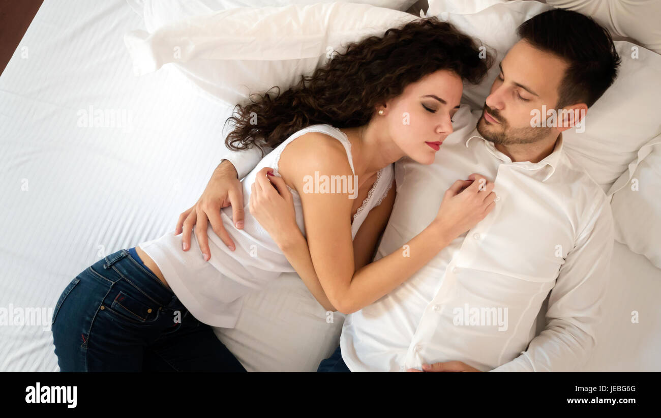 Young cute couple lying together on bed Stock Photo