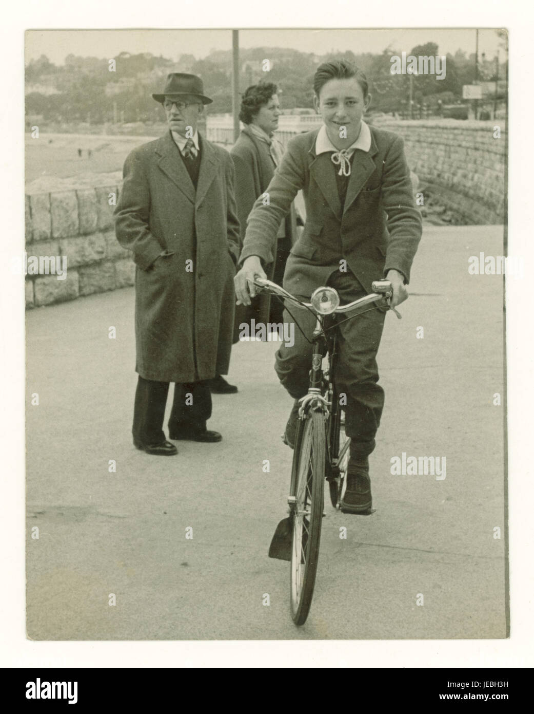 Original vintage cycling nostalgic photograph of happy carefree teenage age boy on his bike on Torquay promenade - a typical British seaside town, possibly on holiday, 1940's, Torquay, Devon, U.K. Stock Photo